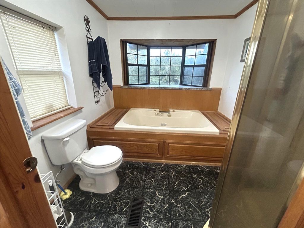Full bathroom featuring a garden tub and crown molding