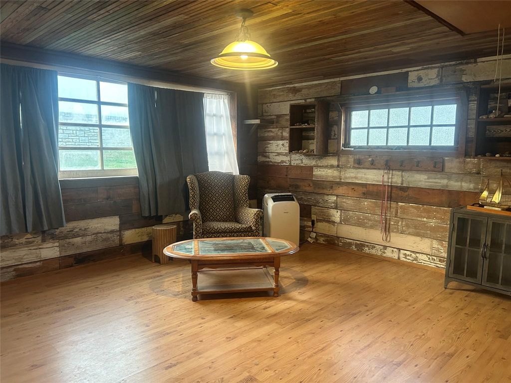 Sitting room with wooden walls, wooden ceiling, and wood finished floors