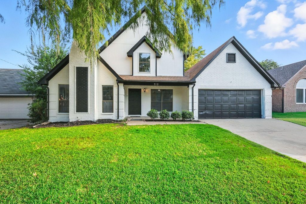 Modern inspired farmhouse with a front lawn, covered porch, brick siding, and concrete driveway