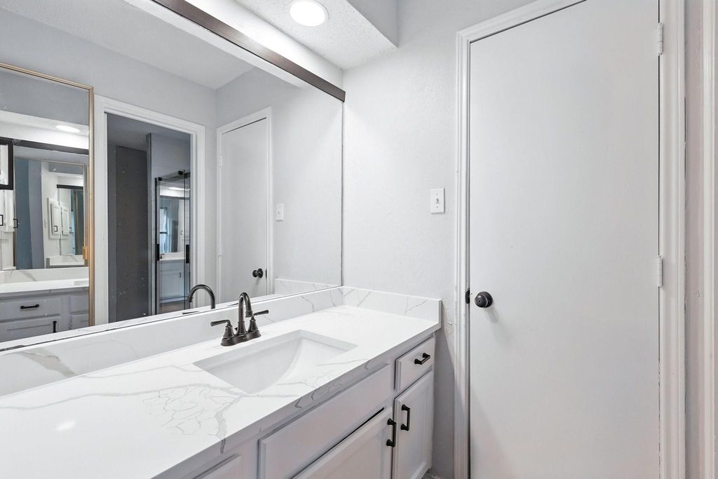 Full bath with vanity and quartz counter top.