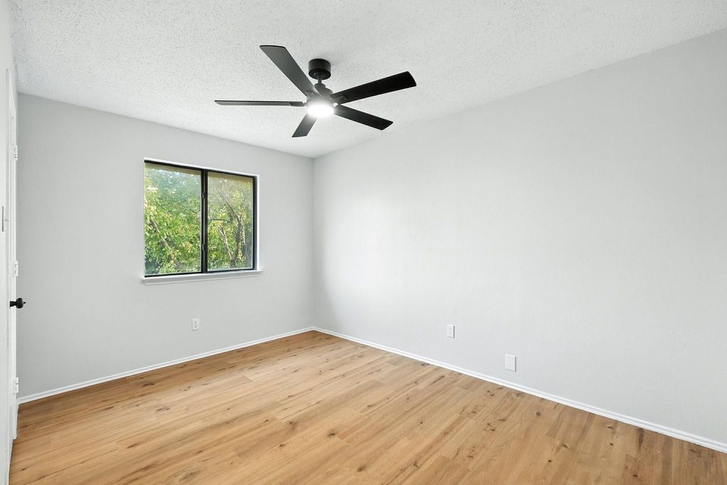 Unfurnished bedroom with a textured ceiling, light wood-type flooring, and ceiling fan