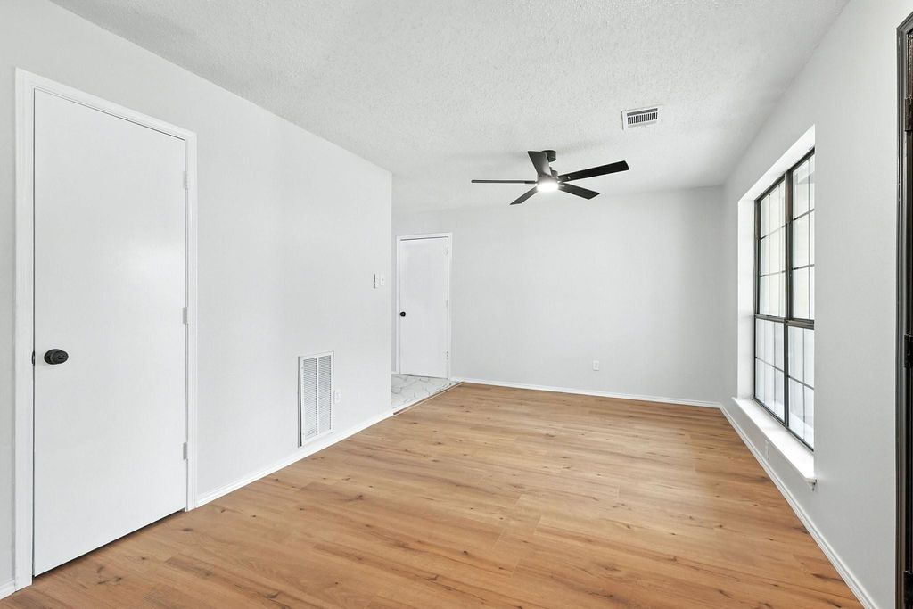 Dining room featuring light wood finished floors, a textured ceiling, and a ceiling fan