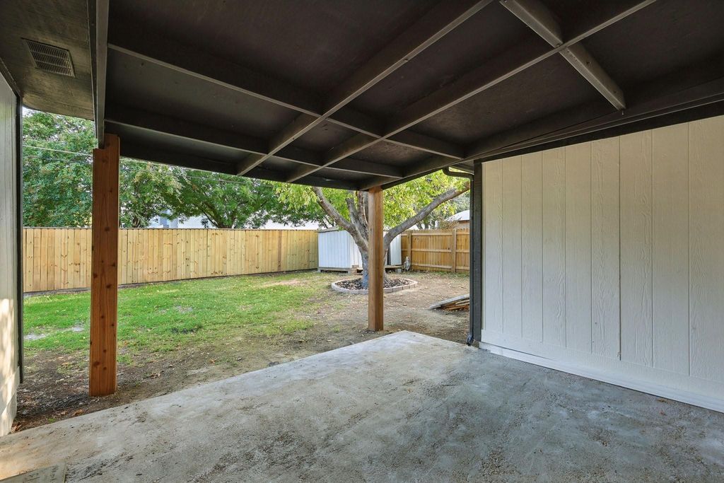 Fenced backyard featuring a patio area and a storage shed