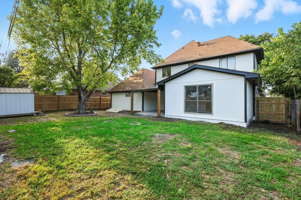 Back of house with a patio, a fenced backyard, and a shingled roof