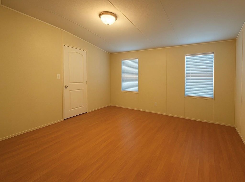 Unfurnished room with light wood finished floors and lofted ceiling