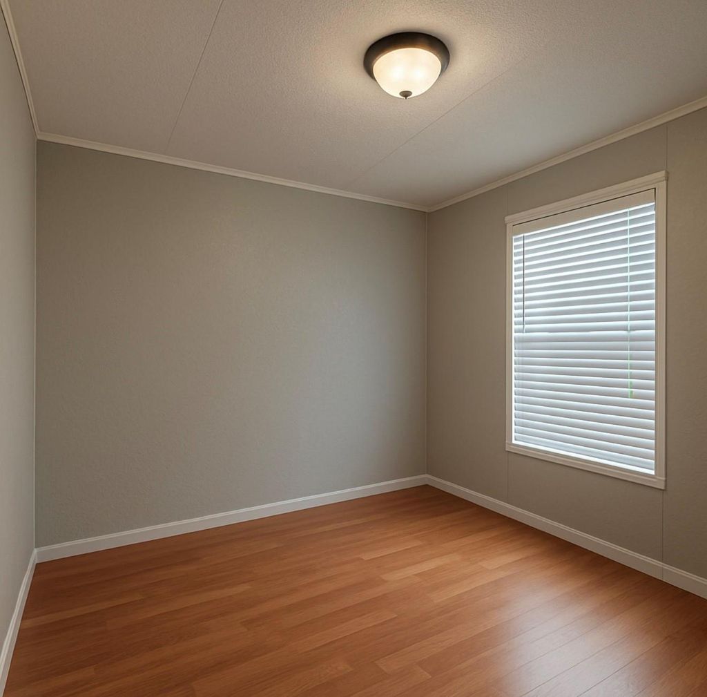 Empty room with light wood finished floors, crown molding, and a textured ceiling