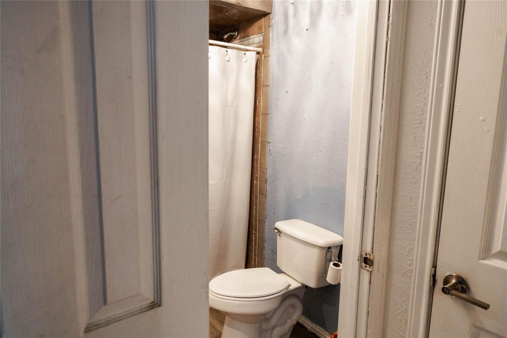 Bathroom with toilet and a textured wall