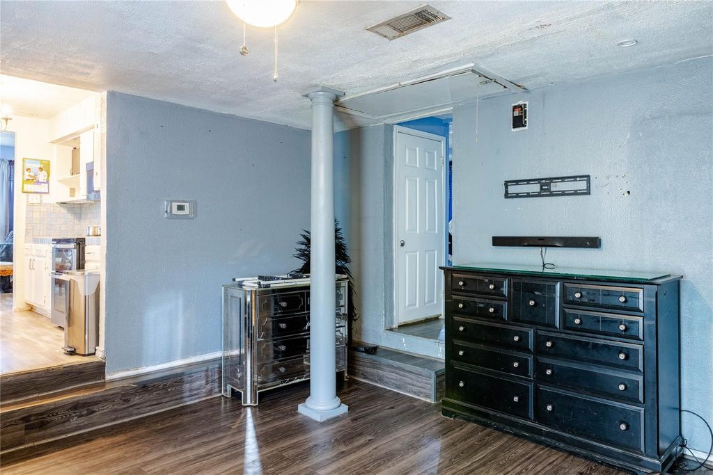 Bedroom with attic access and dark wood-style floors