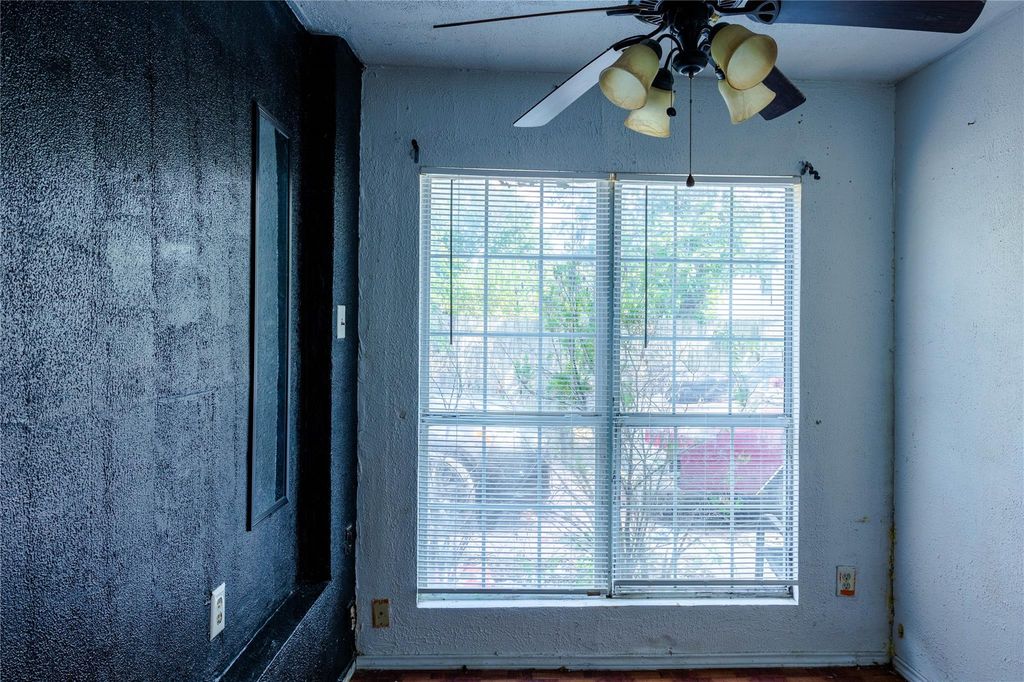 Spare room with a textured wall and ceiling fan