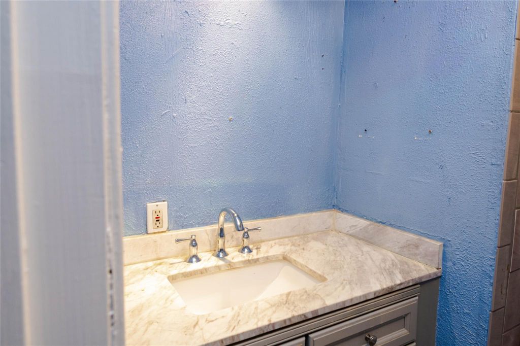 Bathroom with a textured wall and vanity