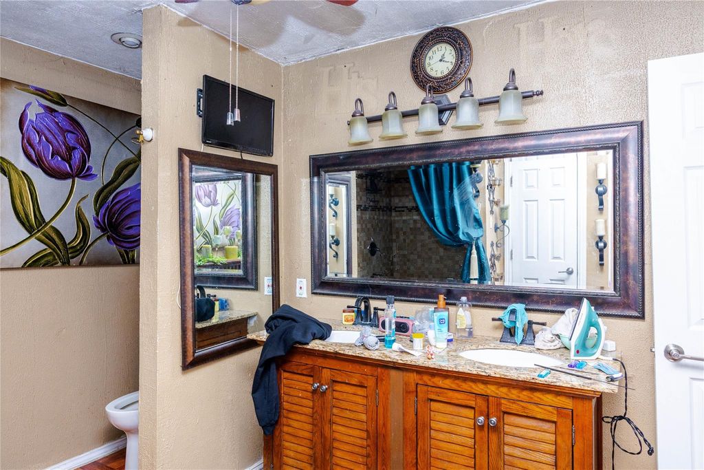 Full bathroom with a textured wall and vanity