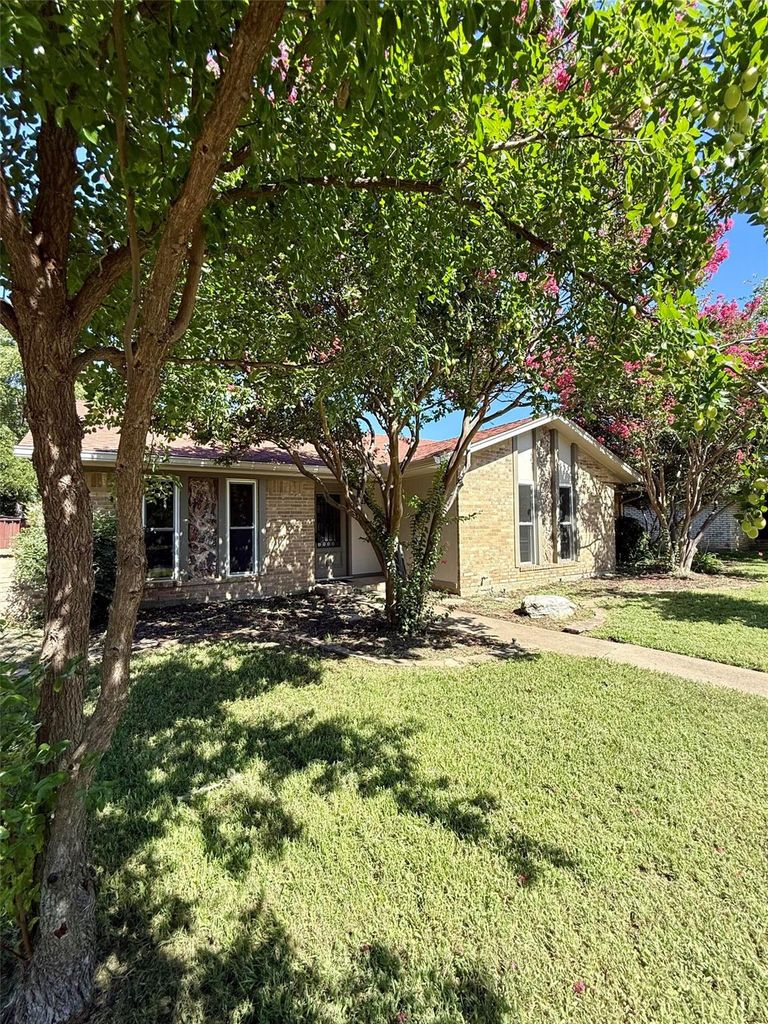 Ranch-style home with brick siding and a front lawn