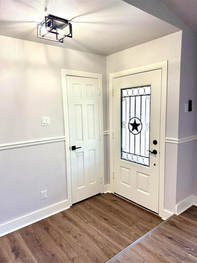 Foyer entrance featuring dark wood-style flooring and a textured ceiling