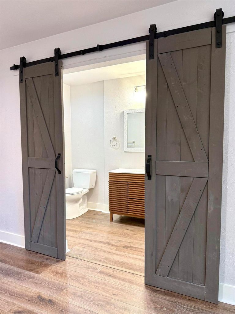 Half bathroom featuring wood finished floors and vanity