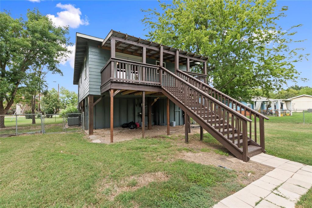 Rear view of property featuring a wooden deck, stairway, and a gate
