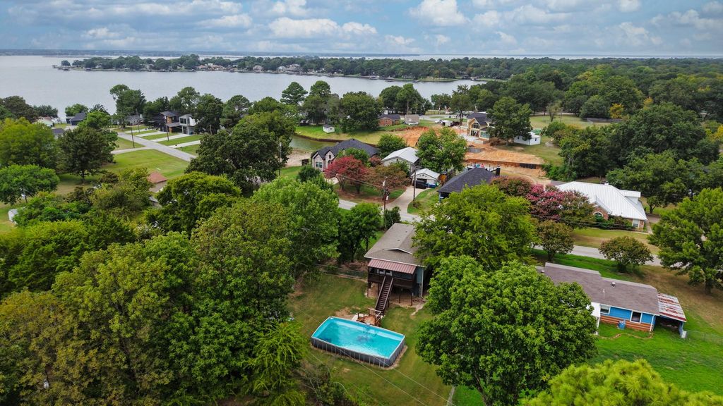 Aerial perspective of suburban area featuring a large body of water and a pool area