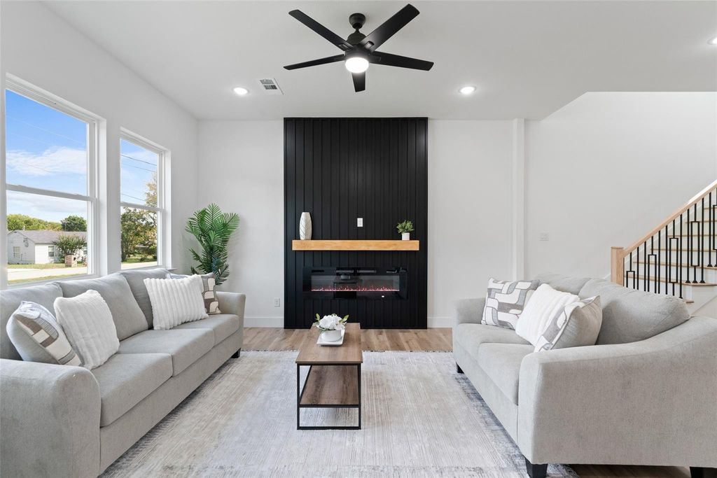 Living room featuring wood finished floors, recessed lighting, a glass covered fireplace, ceiling fan, and stairway