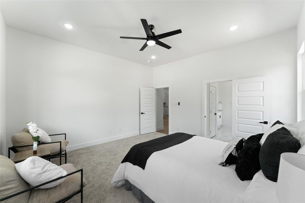 Bedroom with light colored carpet, recessed lighting, ceiling fan, and connected bathroom