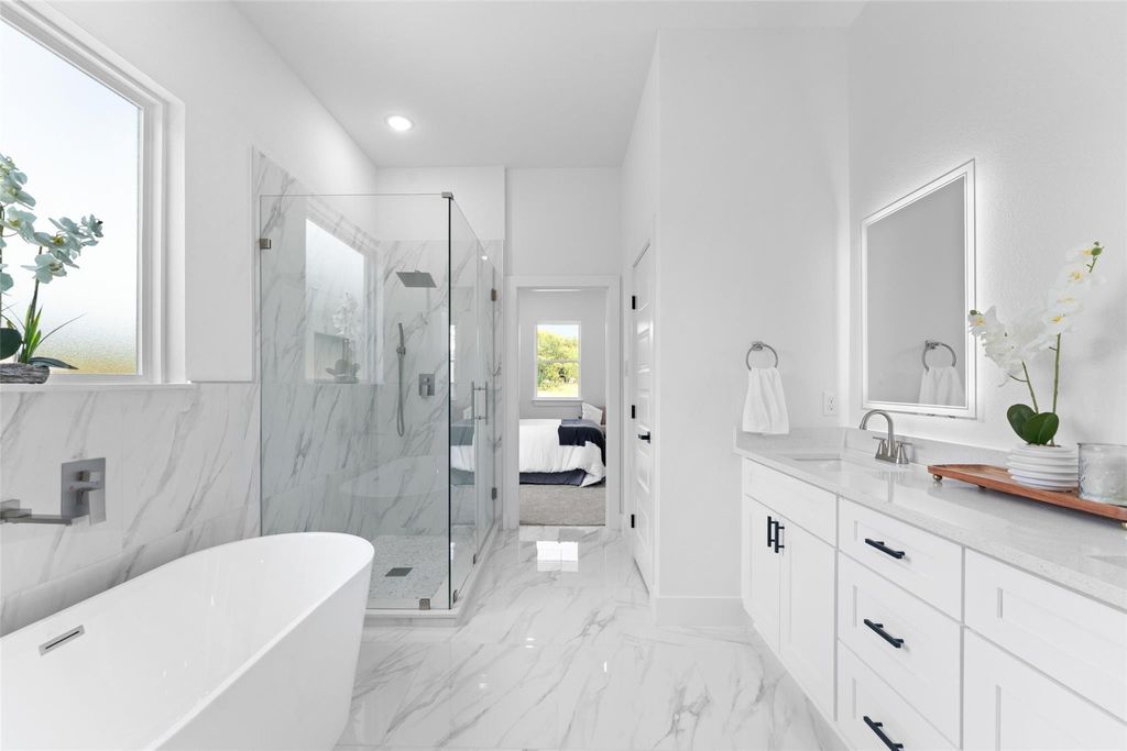 Bathroom with ensuite bathroom, vanity, a freestanding bath, a marble finish shower, and recessed lighting