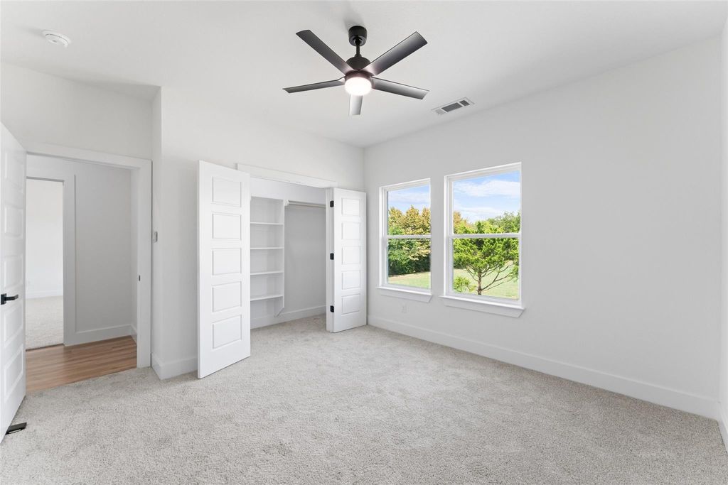 Unfurnished bedroom with light carpet, ceiling fan, and a closet