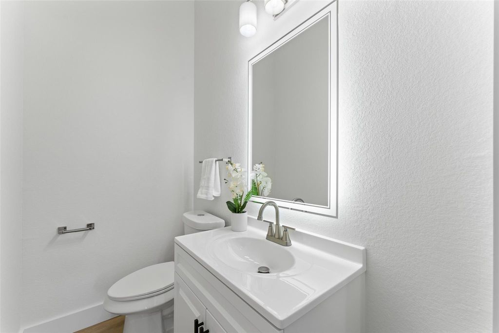 Half bathroom with vanity and a textured wall
