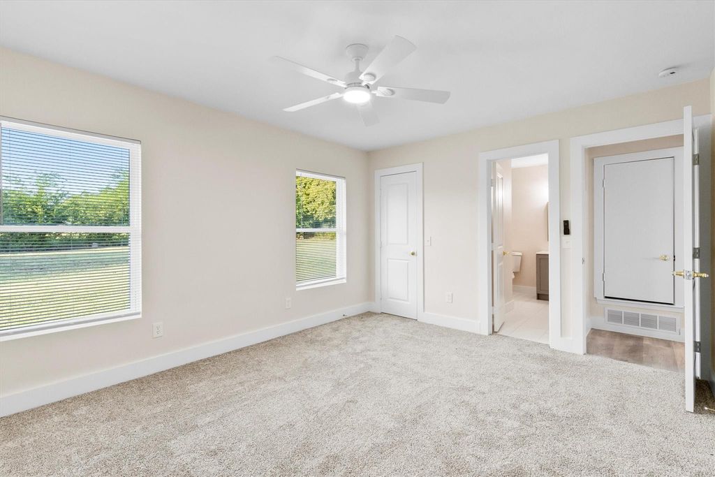 Unfurnished bedroom with light colored carpet, ceiling fan, and a closet