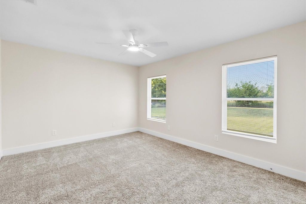 Spare room featuring light carpet and ceiling fan