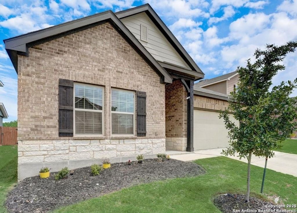 View of front facade with concrete driveway, a garage, and brick siding