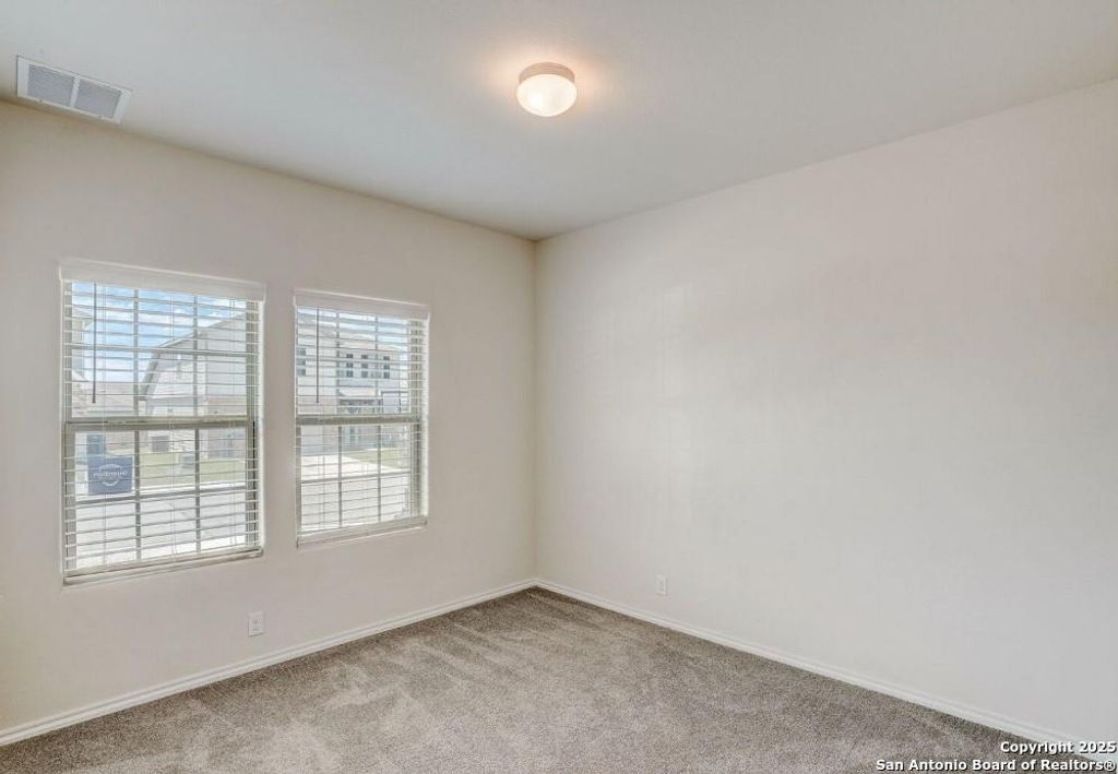 Empty room with light carpet and baseboards