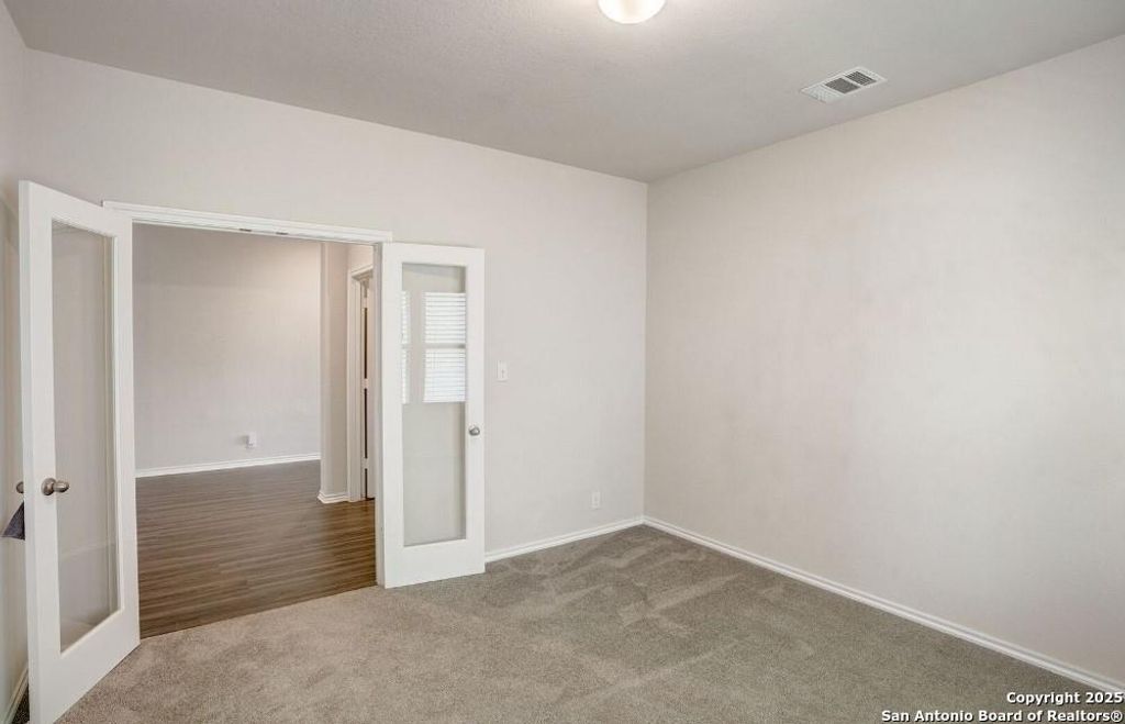 Spare room featuring french doors and carpet floors