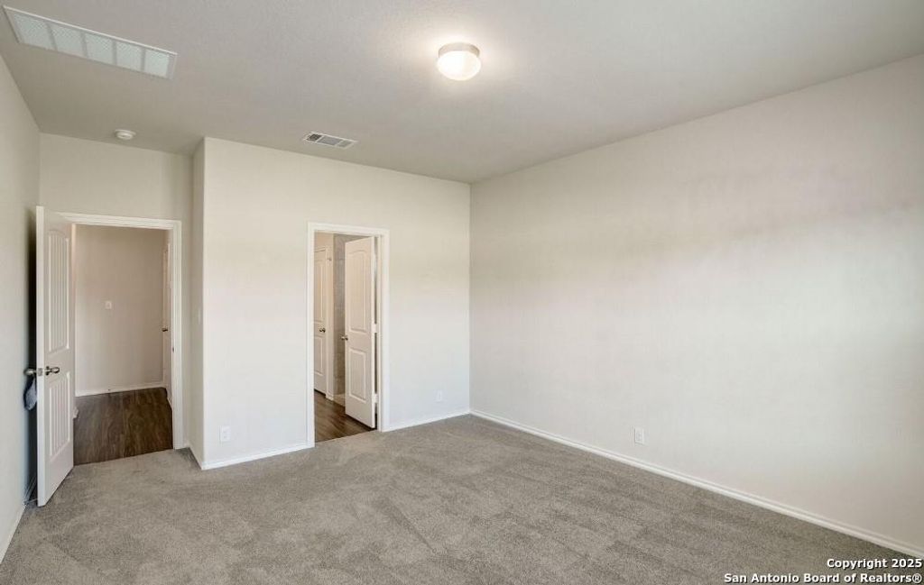 Unfurnished bedroom with carpet floors and baseboards