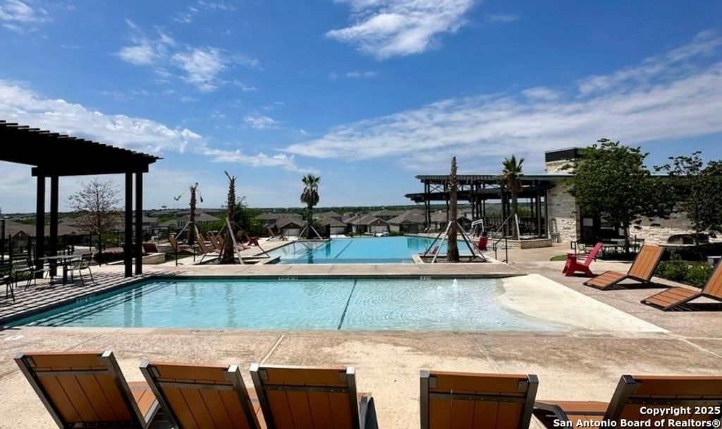 Community pool with a patio area and a pergola