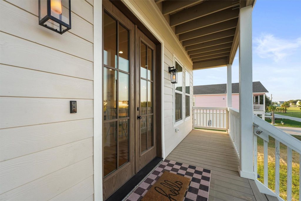 Inviting covered porch with French doors and charming lighting