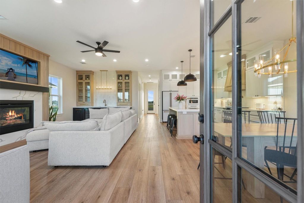 Open-concept living, dining, and kitchen with seamless flow, wide-plank wood flooring, and designer finishes.