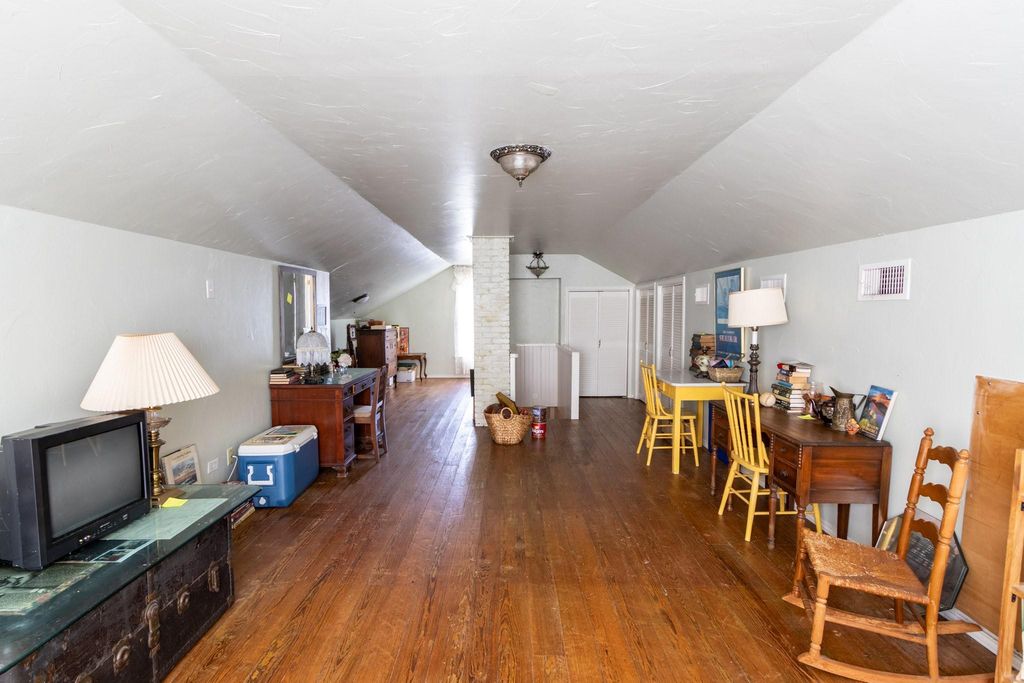 View of the 2nd floor looking from the front of the house. Staircase is in the center background. Full bath is around the corner to the right from the white painted chimney. 