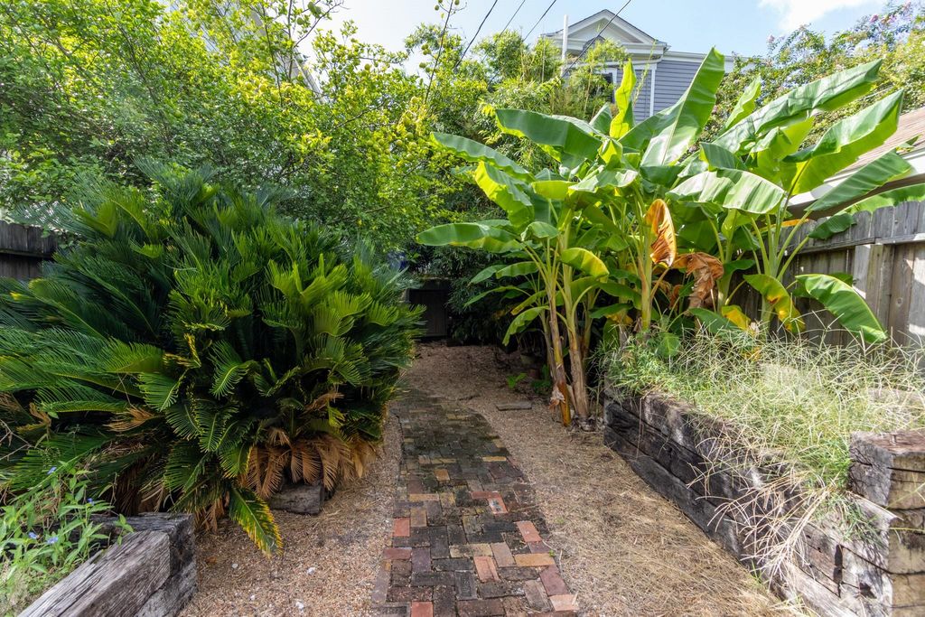 From the back porch there is a brick path to the alley gate. Raised beds on either side.  Shady and secluded. 