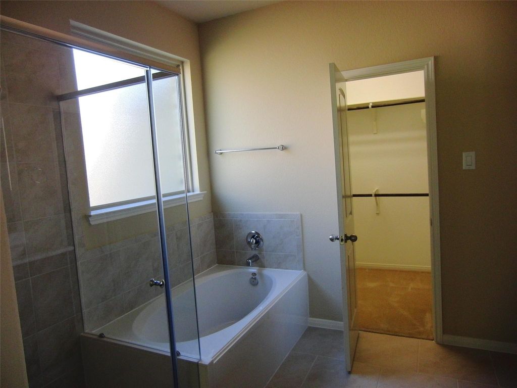 Master bathroom featuring a separate shower and relaxing tub.