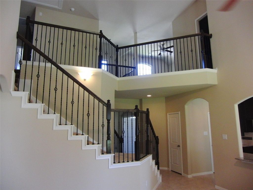 Experience elegance with soaring ceilings and sleek metal railings leading to the second floor.