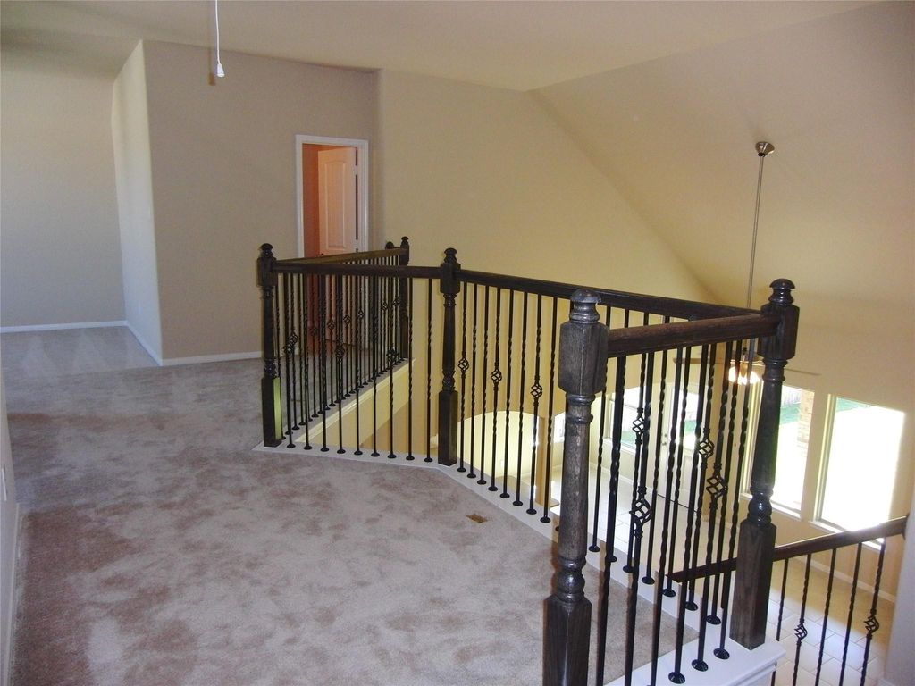 Upstairs landing area with carpeted flooring. The space is bright, with natural light.