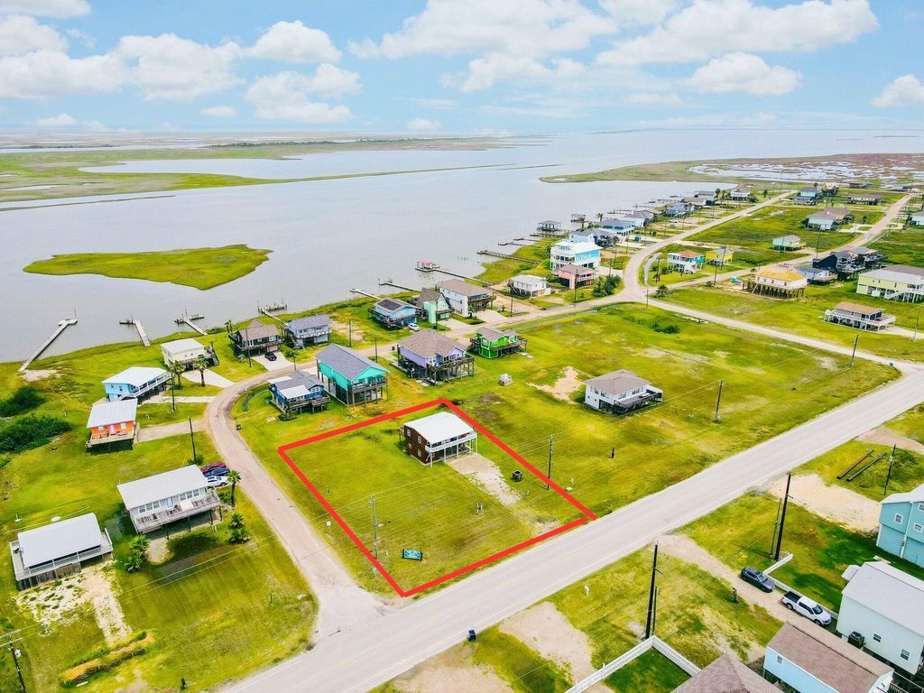 This photo shows a spacious, grassy lot with estimated boundary outlined in red in a peaceful neighborhood. 