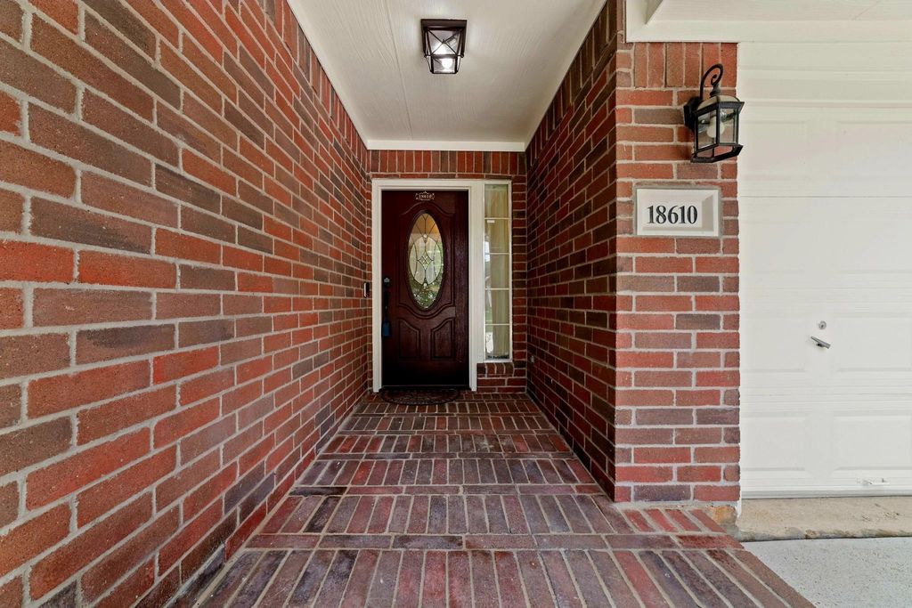 Stepping onto the covered patio, welcomed by a crafted fiberglass door and adorned of elegant glass surrounded in timeless brick and mortar — the cozy feeling of home as you arrive home.