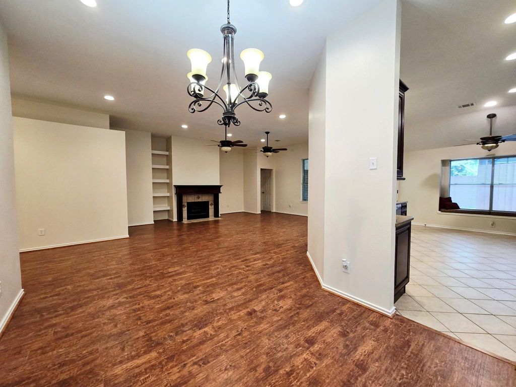This stunning vantage point beautifully showcases three key areas: the spacious dining room, the inviting family area, and the well-equipped kitchen, all enhanced by high ceilings. The warm wood laminate floors contribute to a cozy atmosphere, making it the perfect setting for enjoyable evenings and holiday gatherings. 
