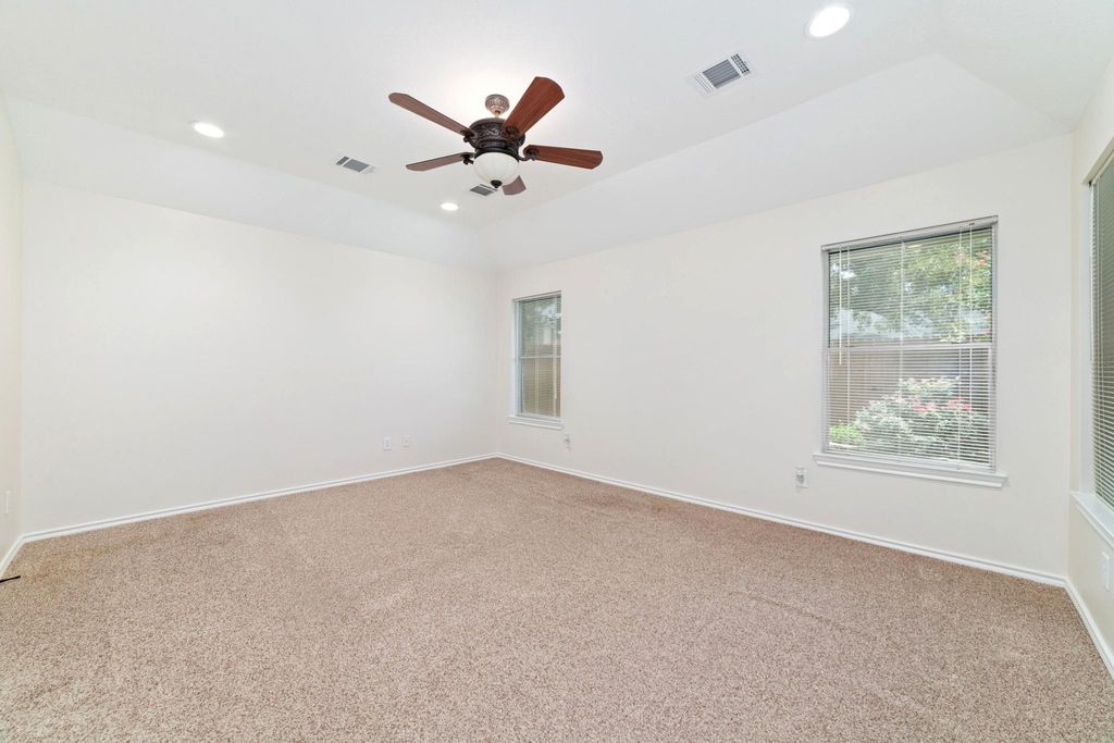 Bright and spacious primary bedroom meets a cozy backyard oasis — your perfect blend of comfort and tranquility.