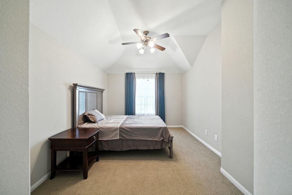 Bedroom 4 features a vaulted ceiling with a ceiling fan, a large window with natural light, and neutral walls.