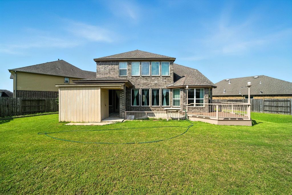 A deck and a spacious lawn, ideal for outdoor activities and entertainment.