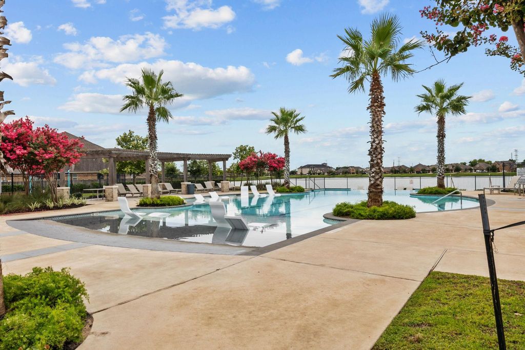 Resort-style community pool with lounge seating and lake views