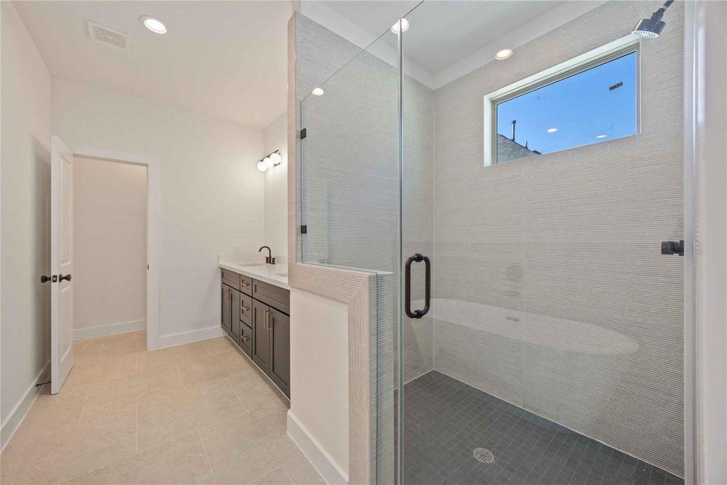 Luxurious primary bath featuring a spacious walk-in shower and elegant double vanity.