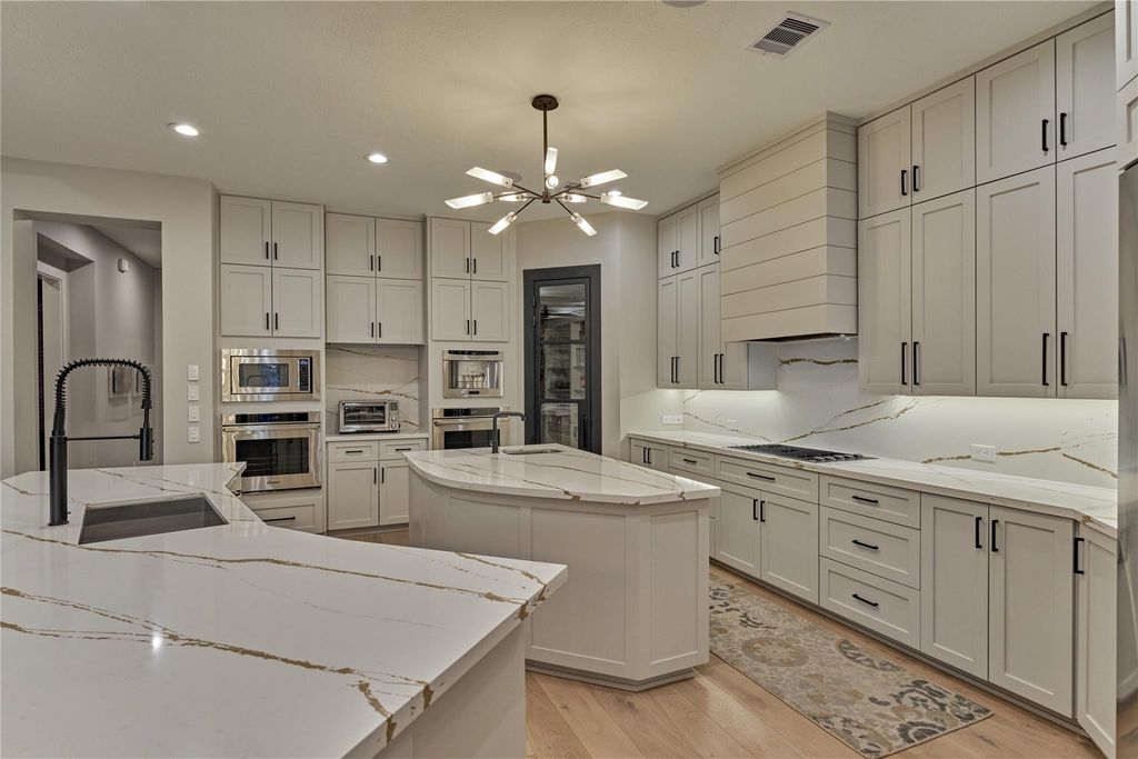 This photo captures the Dacor Appliances featuring two ovens and a microwave. The Built-in coffee machine is Thermador. 