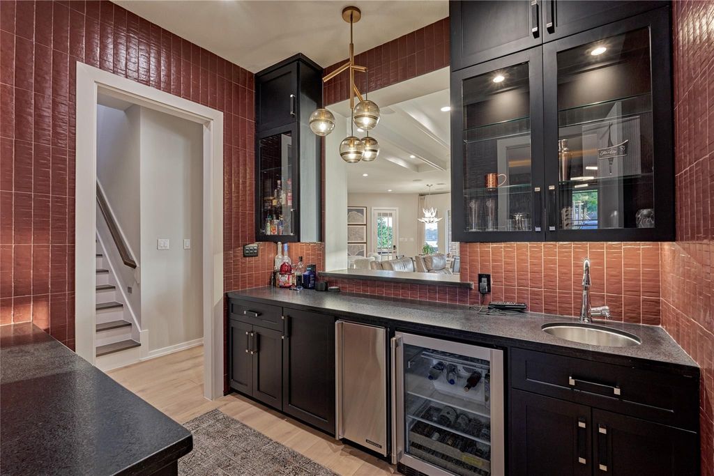 This is the fabulous wet bar as seen in a previous photo. Amenities include an ice maker, a wine fridge and wine racks. Also featured is another magnificent light fixture. 