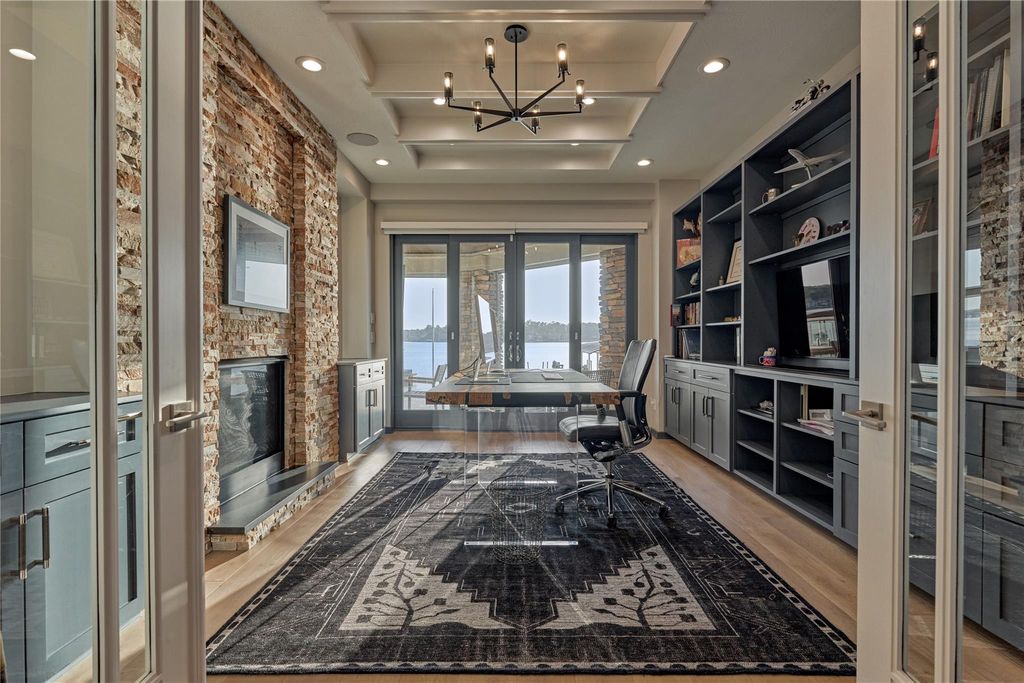 And the luxurious features continue to impress as found here in the executive study. One feature wall boasts of a stacked stone gas fireplace and the back wall features built-in cabinets and shelving. This work space is truly inspiring, especially with captivating lake views just outside your windows!